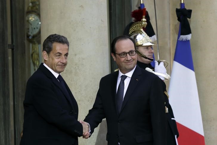 © Reuters. French President Hollande shakes hands with former French President Sarkozy at the Elysee Palace in Paris