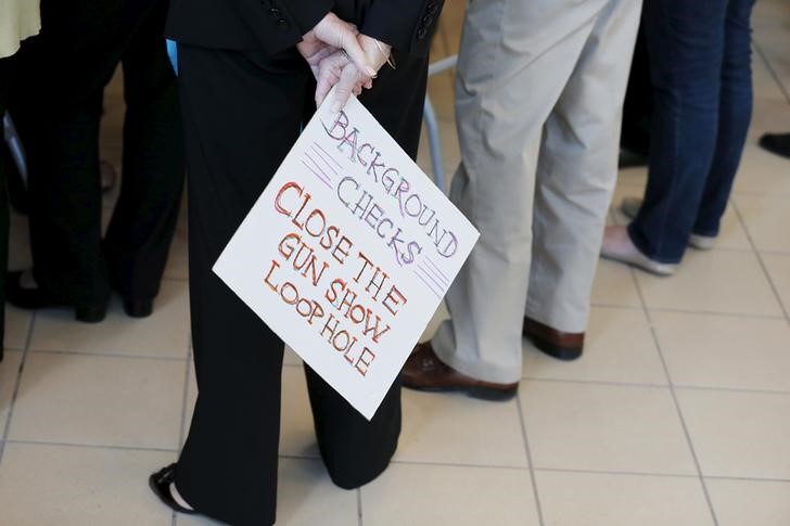 © Reuters. An audience member holds a hand lettered sign calling for further gun control at a campaign stop with U.S. Democratic presidential candidate Hillary Clinton in Nashua