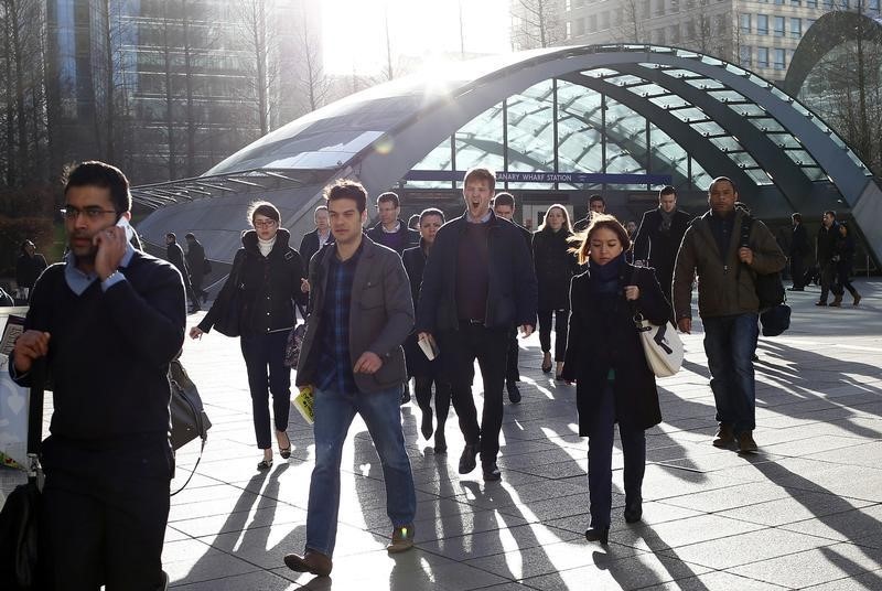 © Reuters. Workers leave the underground station at the Canary Wharf business district in London