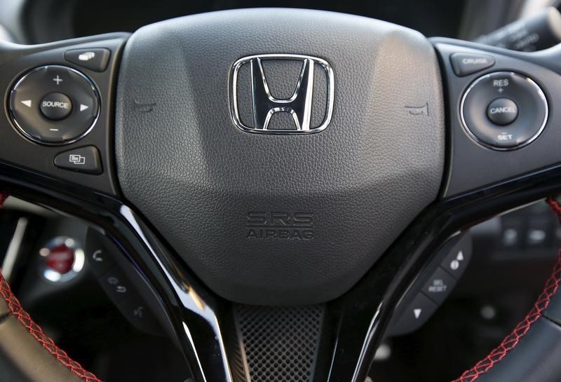 © Reuters. The logo of Honda Motor Co and an airbag logo are seen on a steering wheel of a car displayed at the company's showroom in Tokyo