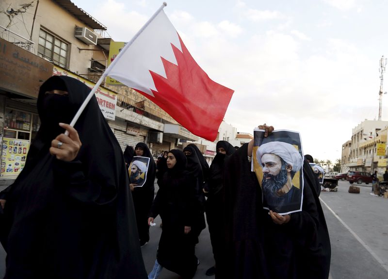 © Reuters. Manifestantes com fotos do clérigo executado Nimr al-Nimr e a bandeira do Barein protestam no Barein