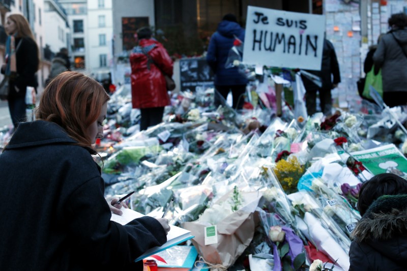 © Reuters. Mulher prestando homenagem a vítimas dos ataques de militantes islâmicos contra o semanário satírico Charlie Hebdo, em Paris