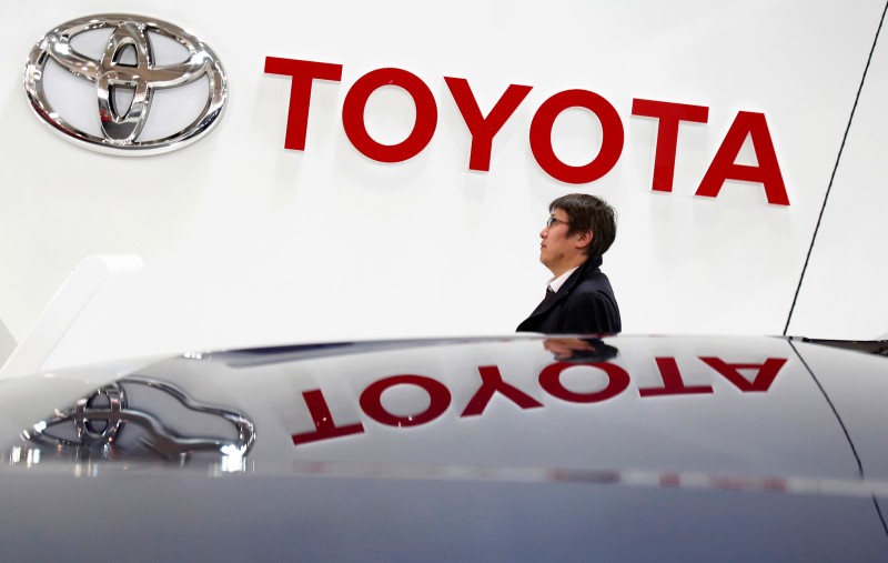 © Reuters. A visitor walks under a logo of Toyota Motor Corp at the company's showroom in Tokyo