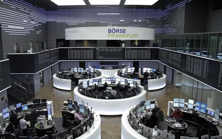 © Reuters. Traders are pictured at their desks in front of the DAX board at the stock exchange in Frankfurt