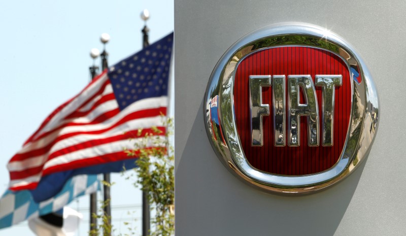 © Reuters. A U.S. flag flutters in the wind behind a  Fiat logo at a car dealership in Alexandria