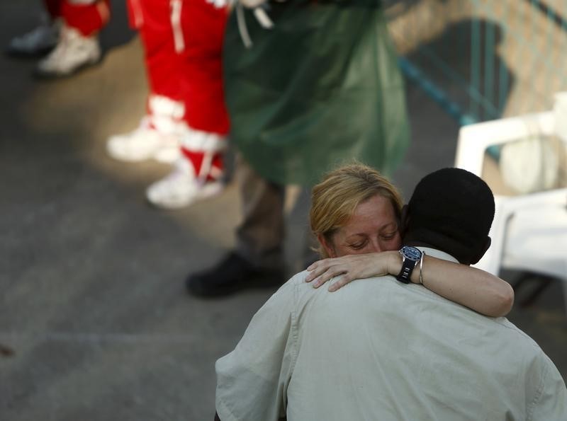 © Reuters. Migrant and the Medecins Sans Frontiere (MSF) team leader embrace as migrants disembark from the MSF rescue ship Bourbon Argos in Trapani, on the island of Sicily