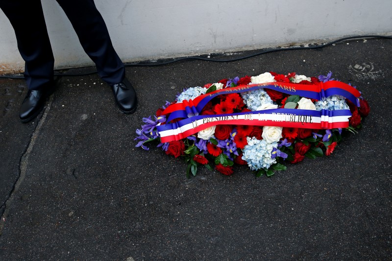 © Reuters. A wreath of flowers is seen during a ceremony to unveil a commemorative plaque to pay tribute to the victims of the last year's January attacks outside the former offices of French weekly satirical newspaper Charlie Hebdo in Paris