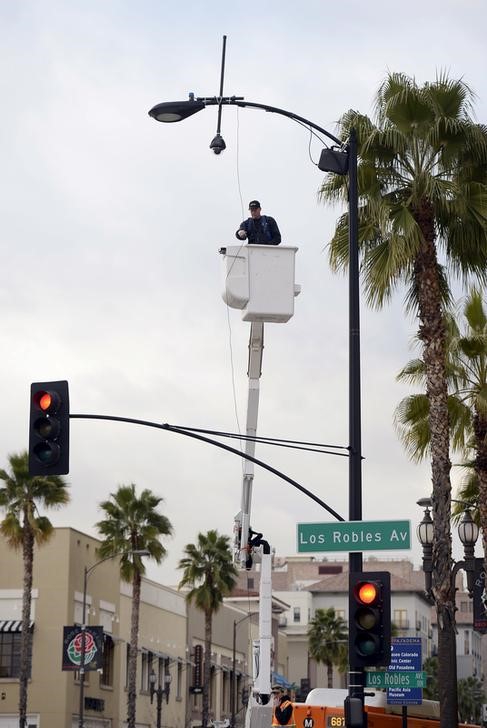 © Reuters. Operaio monta una telecamera di sorveglianza a Pasadena.