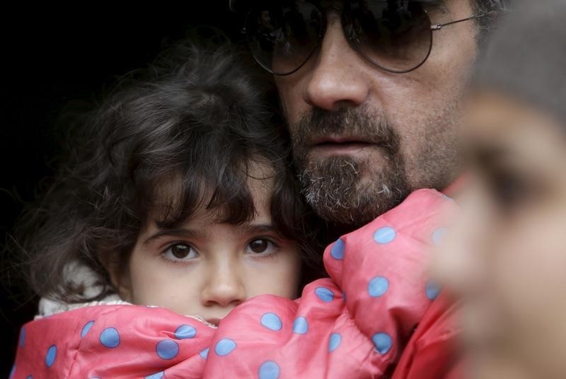 © Reuters. A Syrian migrant holds his child at a temporary refugee camp in Gabcikovo, Slovakia