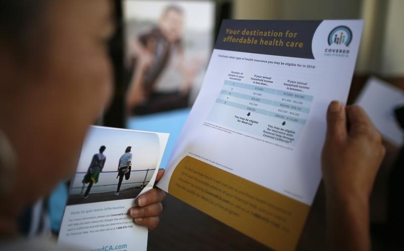 © Reuters. Campos, who has no health insurance and diabetes, browses leaflets at a Covered California event in Los Angeles