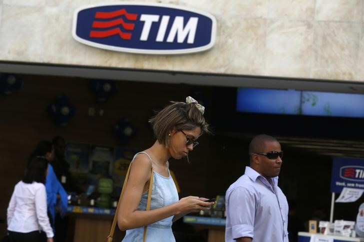 © Reuters. People walk in front of a Telecom Italia Mobile (TIM) store in downtown Rio de Janeiro
