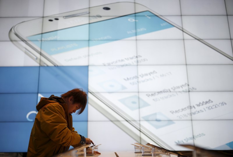 © Reuters. A man tries out a Samsung Electronics' mobile device at its headquarters in Seoul