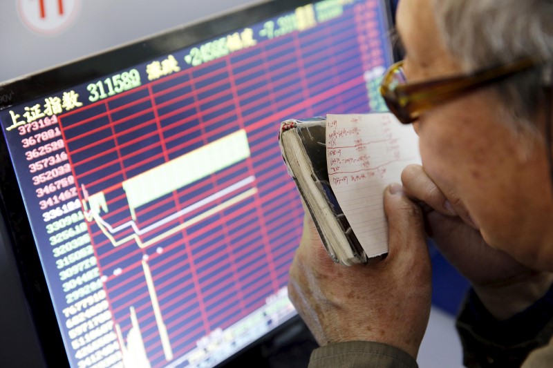 © Reuters. An investor looks at a screen showing stock information, after the new circuit breaker mechanism suspended today's stocks trading, in Shanghai