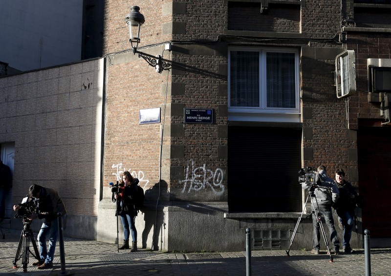 © Reuters. Reporters stand near a street sign which reads "Henri Berge" in the Brussels district of Schaerbeek