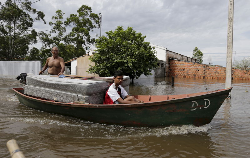 © Reuters. Paraguayans remove their belongings on a boat from their flooded houses near the Paraguay river in Asuncion