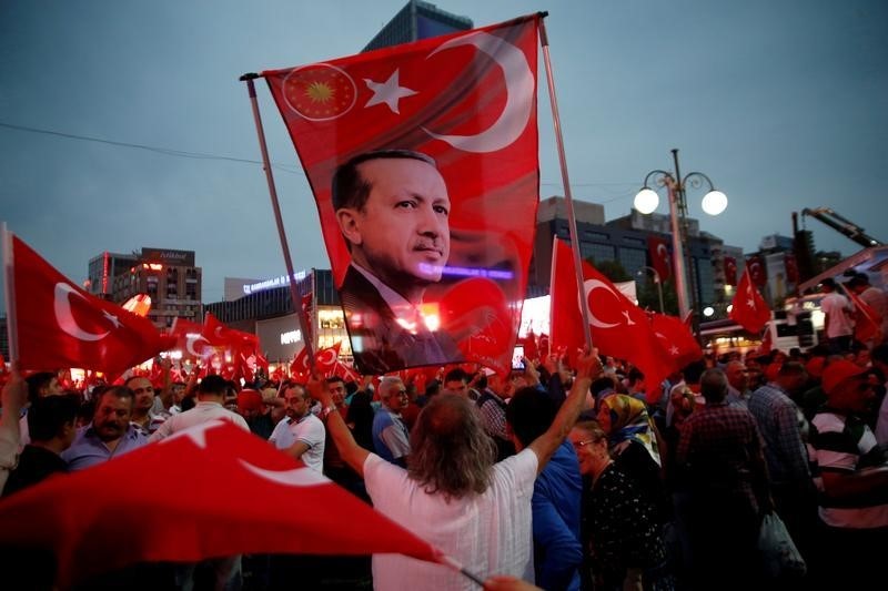 © Reuters. A supporter holds a flag depicting Turkish President Tayyip Erdogan during a pro-government demonstration in Ankara