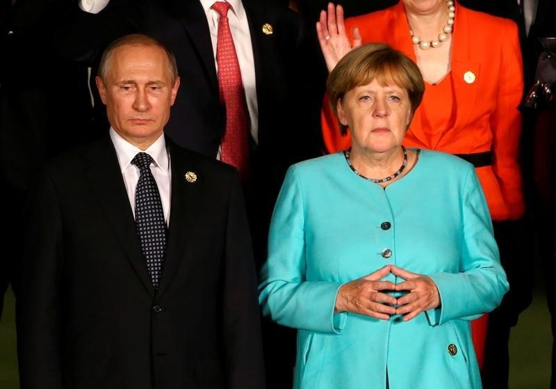 © Reuters. Chanceler alemã, Angela Merkel, e presidente da Rússia, Vladimir Putin, durante evento na China