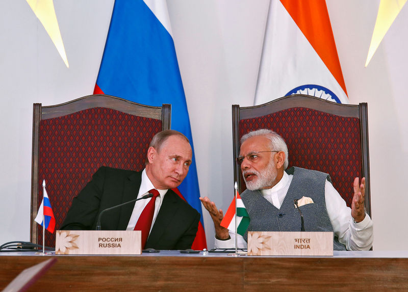 © Reuters. India's Prime Minister Narendra Modi speaks with Russian President Vladimir Putin during exchange of agreements event after India-Russia Annual Summit in Benaulim, in the western state of Goa