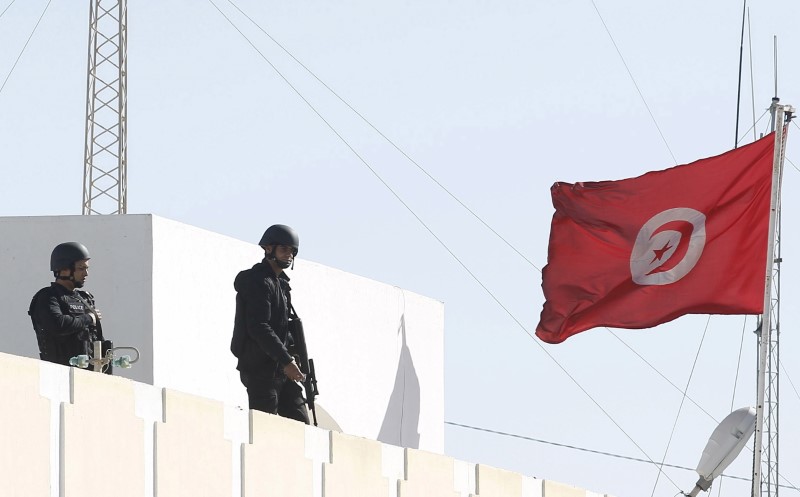 © Reuters. Tunisian policemen patrol the roof of a police station, after Monday's attack by Islamist fighters on an army and police barracks in the town of Ben Guerdan