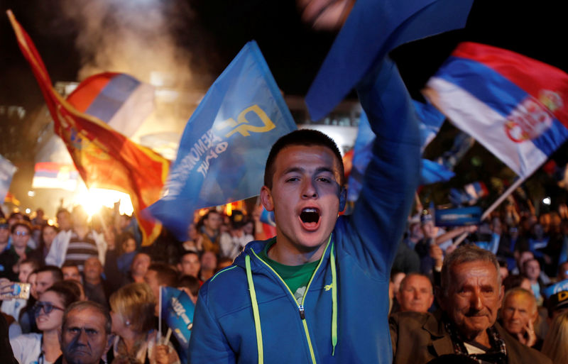 © Reuters. Supporter of opposition Democratic Front alliance shout slogans during their pre-election rally in Podgorica