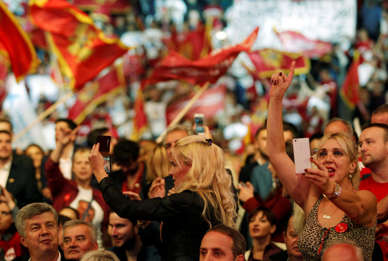 © Reuters. A supporter of rulling Democratic Party of Socialist takes a selfie during a pre-election rally in Podgorica