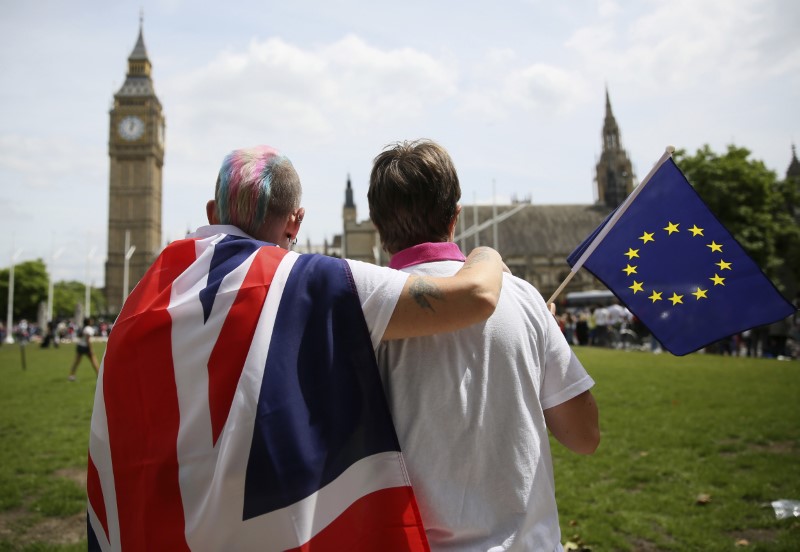 © Reuters. Participants holding a British Union flag and an EU flag kiss during a pro-EU referendum event at Parliament Square in London