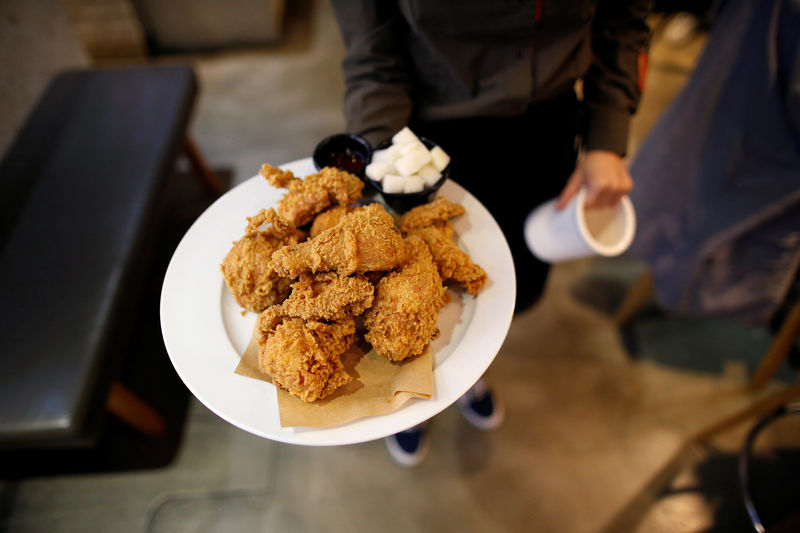 © Reuters. An employee serves fried chicken at a pub in Seoul