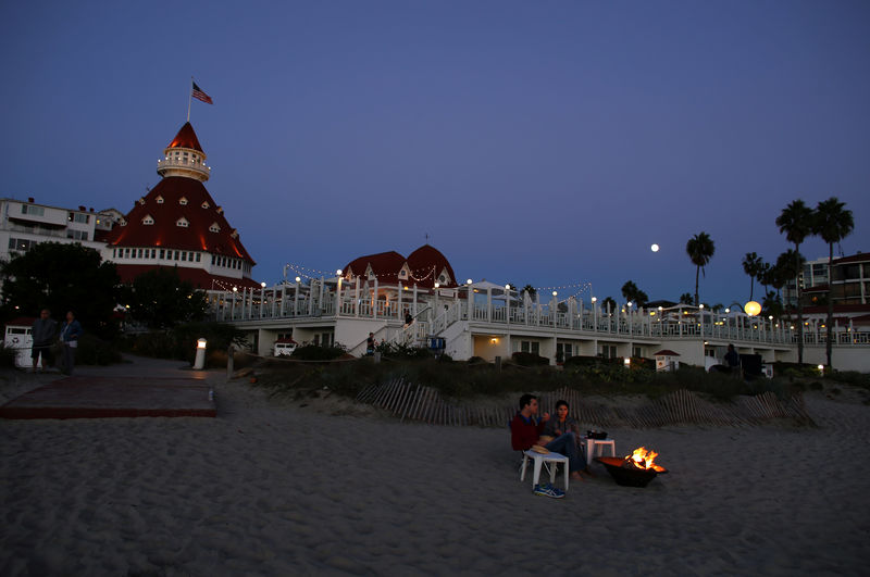 © Reuters. A couple sit by a fire on the beach as tech nerds and stock traders gather for StockTwits annual Stocktoberfest on the beach at Hotel Del in Coronado, California