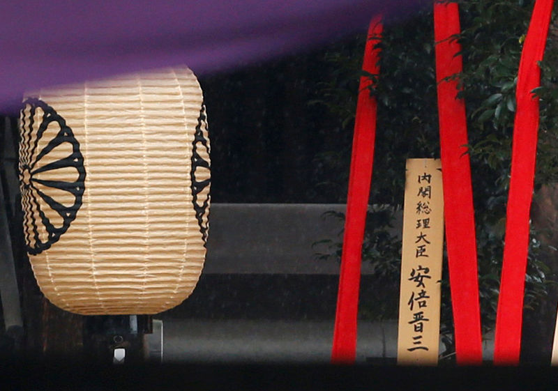 © Reuters. A wooden sign which reads "Prime Minister Shinzo Abe" is seen on a ritual offering, a masakaki tree, from Abe to the Yasukuni Shrine, inside the main shrine at the controversial shrine for war dead in Tokyo