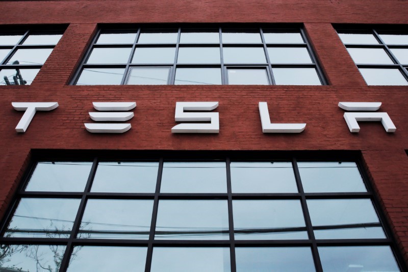 © Reuters. A Tesla logo hangs on a building outside of a Tesla dealership in New York