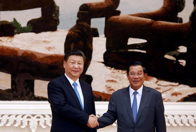 © Reuters. Chinese President Xi Jinping and Cambodian Prime Minister Hun Sen shake hands as they pose for a picture at the Prime Minister's office in Phnom Penh