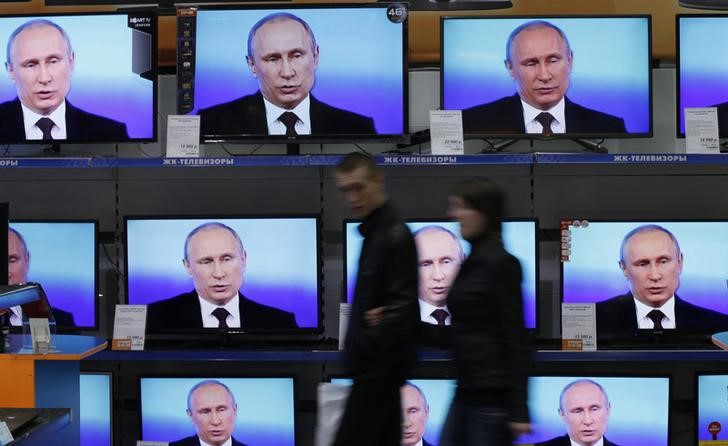 © Reuters. Телевизоры, транслирующие выступление президента РФ Владимира Путина, в магазине электроники в Красноярске