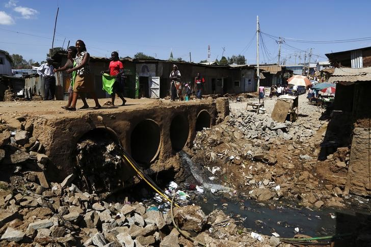 © Reuters. People walk near open sewers in the Kibera slum of Kenya's capital Nairobi