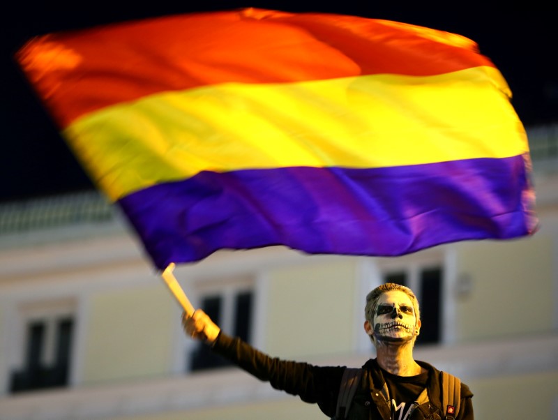 © Reuters. A man waves a Republican flag during a protest against the investiture of  Prime Minister and Popular Party leader Mariano Rajoy in Madrid