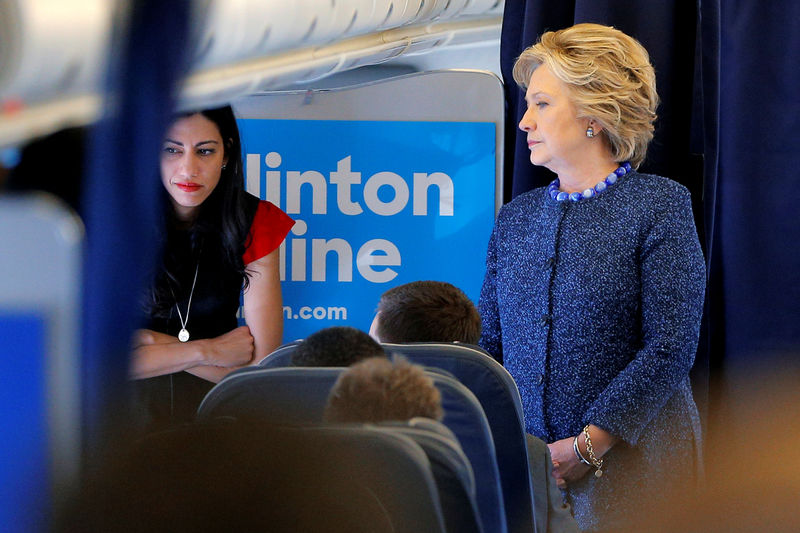 © Reuters. U.S. Democratic presidential nominee Hillary Clinton talks to staff members, including aide Huma Abedin, onboard her campaign plane in White Plains