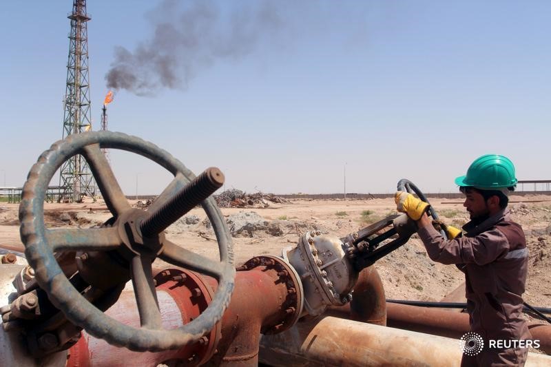 © Reuters. Рабочий проверяет вентиль нефтепровода на НПЗ Аль-Шейба в Басре, Ирак
