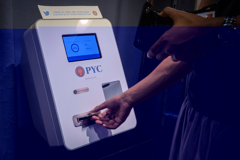 © Reuters. A customer feeds cash currency in to a Bitcoin ATM located in Flat 128, a boutique in New York's West Village