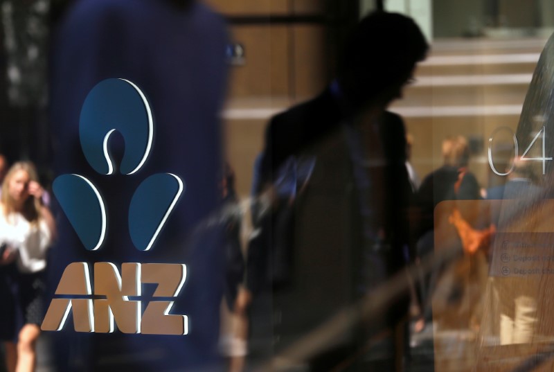 © Reuters. Pedestrians are reflected on a window of ANZ Bank located in central Sydney, Australia