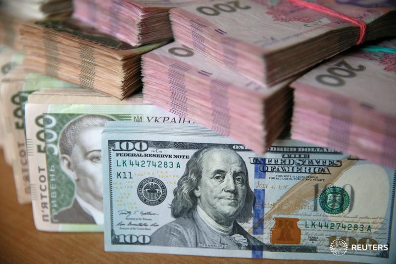 © Reuters. Пачки купюр валют доллар США и гривна в Киеве