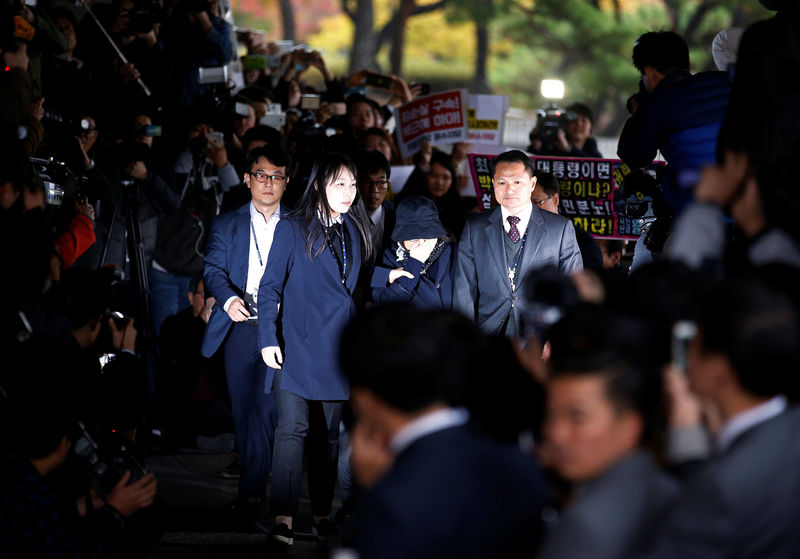 © Reuters. Choi makes her way upon her arrival at a prosecutor's office in Seoul