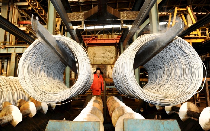 © Reuters. A worker stands near a stainless steel product line at a factory in Dalian