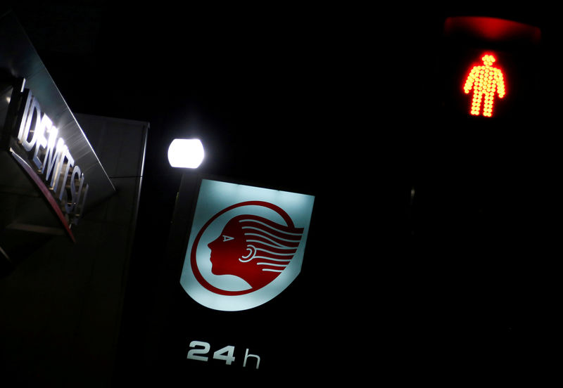 © Reuters. A signboard of Idemitsu Kosan Co is seen behind a traffic light at its gas station in Tokyo, Japan
