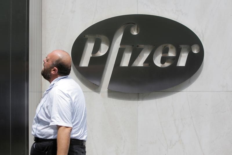 © Reuters. Мужчина проходит мимо офиса Pfizer в Нью-Йорке