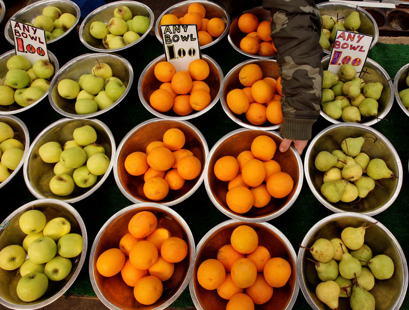 © Reuters. A market stall owner displays fruits in Leicester