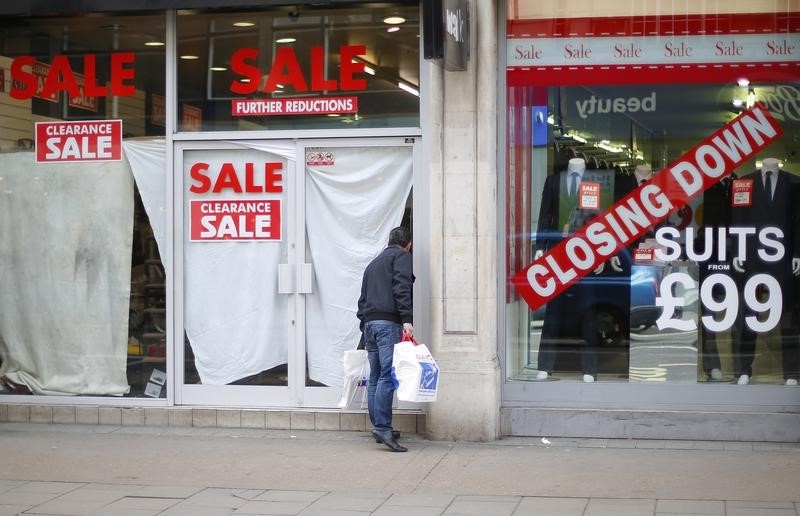 © Reuters. A man peers into a closed down shop in central London