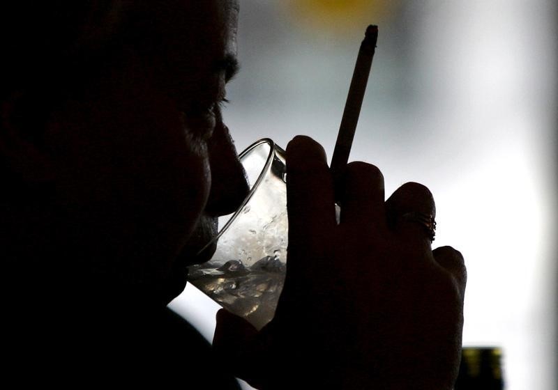 © Reuters. A man holds a cigarette as he sips a drink in a JD Wetherspoon pub in London.