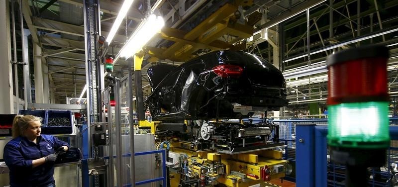 © Reuters. An employee of German car manufacturer Mercedes Benz observes the connection between the bodywork and the chassis of an A class (A-Klasse) model at their production line at the factory in Rastatt