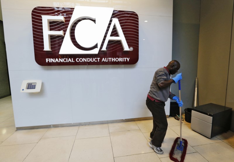 © Reuters. A maintenance worker cleans the entrance area of the headquarters of the new Financial Conduct Authority in the Canary Wharf business district of London