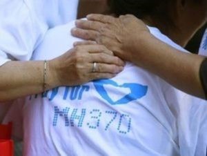 © Reuters. Family members of passengers onboard the missing Malaysia Airlines Flight MH370 comfort a crying woman as they gather to pray at Yonghegong Lama Temple in Beijing