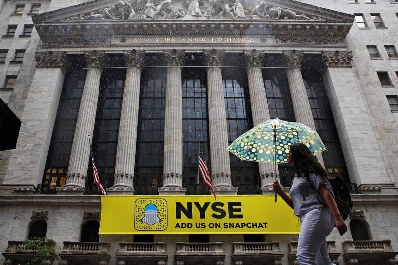 © Reuters. Женщина идет мимо здания Нью-Йоркской фондовой биржи
